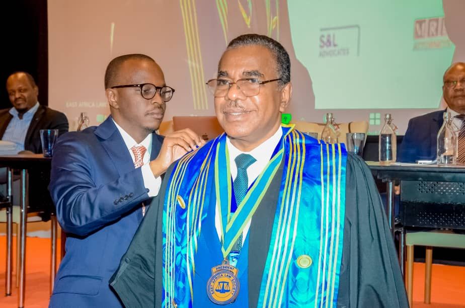 Uganda Law Society (ULS) President Bernard Oundo (L) drapes incoming EALS President, Dr Fauz Twaib (R) with gown in symbolic transfer of power