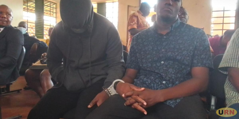 Pastor Joseph Collins Twahirwa wearing a sweater with a hood at Nakawa Court